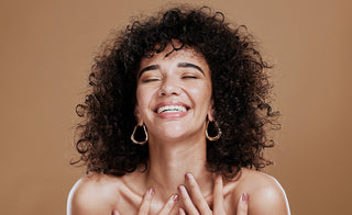 Beauty, self love of a black woman with natural conditioned hair feeling happiness and pride for identity on a brown studio background. Aesthetic model 