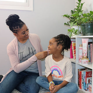 Black mother braiding her daughter's hair